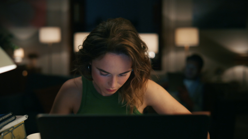 Serious accountant texting home zoom out. Focused woman counting calculating budget alone closeup. Freelance girl preparing weekly report watching laptop at evening remotely. Man using tablet Royalty-Free Stock Footage #1096907121
