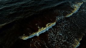 Dark sea water in autumn. Rocky coast of the Pacific Ocean, waves of sea water crashing on the rocks. Dramatic sunset nature.Drone flight over the sea