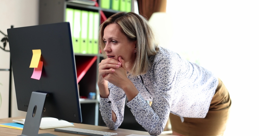 Beautiful woman looks at laptop and expresses shock