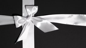 Unwrapping gift revealing a green screen - Stop Motion Animation - White ribbon with bow on a black background. Chroma key. Black Friday. - Powered by Shutterstock - Get 15% off with code: PIKWIZARD15