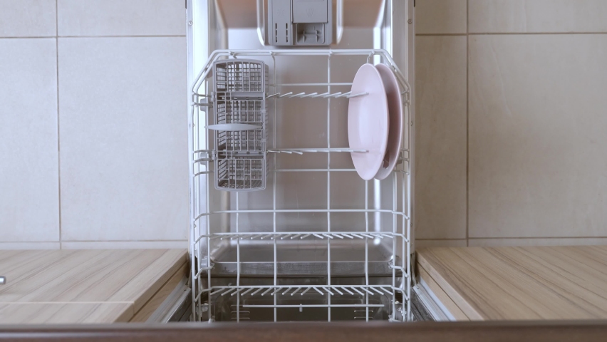 Housewife is loading dirty kitchenware in dishwasher. | Shutterstock HD Video #1096929983