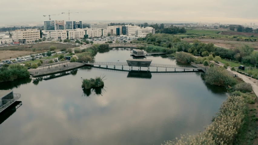 A path adjacent to the lake with reflection of clouds in the park 