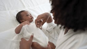 Closeup portrait of beautiful young African American mother day girl kiss healthy newborn baby sleep in bed flat lay copy space. Healthcare medical love black woman lifestyle mother's day. - Powered by Shutterstock - Get 15% off with code: PIKWIZARD15