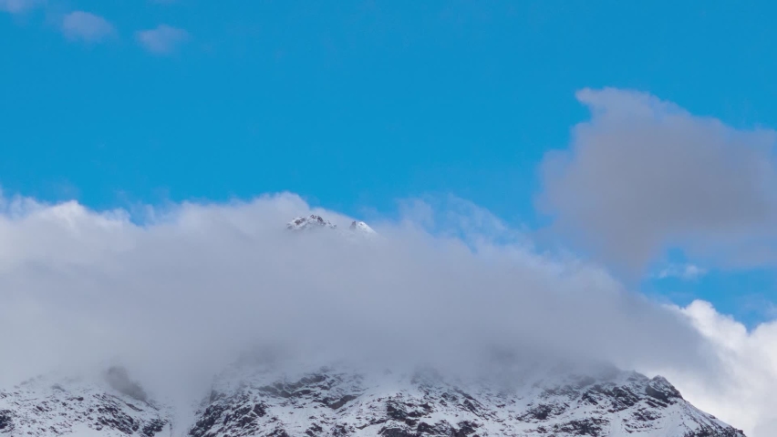 4K Time-lapse of clouds above the snow covered mountain peaks as seen from Keylong in Lahaul Spiti district in Himachal Pradesh, India. White Clouds moving above the snow covered mountain peaks. | Shutterstock HD Video #1096947849