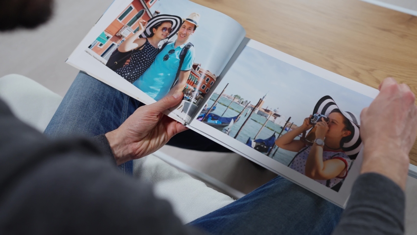 Man Looking At Photo Album Or Photobook