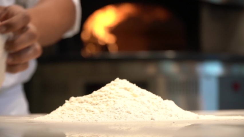 Making wood-fired pizza. The cook prepares pizza with hand dough, makes pizzas with cheese and sauce. He spins the pizza dough, he does it. Royalty-Free Stock Footage #1096949381