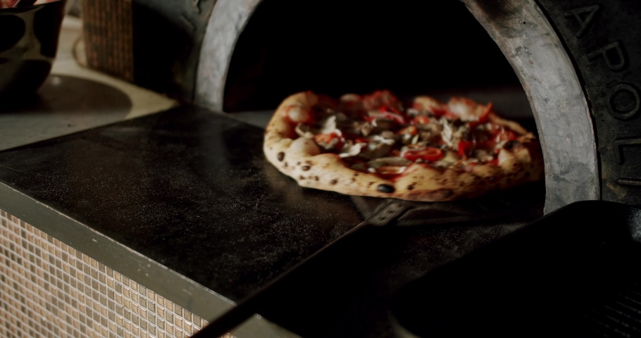 The chef prepares pizza in the restaurant kitchen. Italian Neapolitan pizza with large dough. work in the kitchen. Pizza is placed in the wood oven. Modern Oven. Pizza Food.  Royalty-Free Stock Footage #1096949821