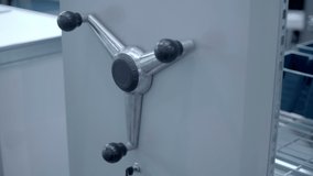 Metal mobile archival shelving with shift handle and closing key with blue empty boxes in shelves in an empty office. Shot in motion. Closeup - Powered by Shutterstock - Get 15% off with code: PIKWIZARD15