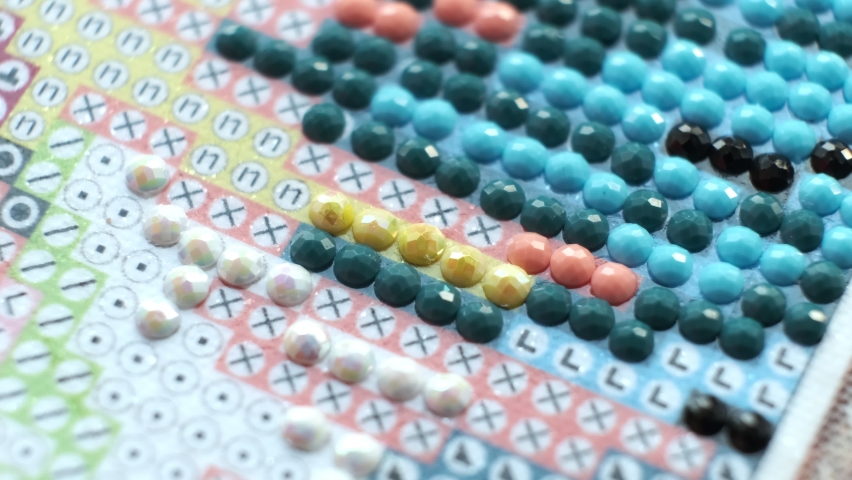 Diamond painting with pen closeup. art therapy concept. Laying out a diamond mosaic improves a woman