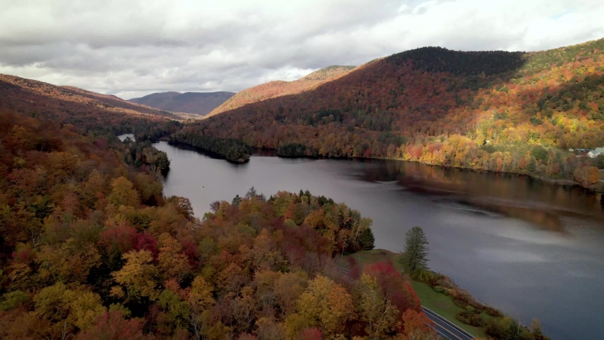new england autumn leaf color over lake in vermont