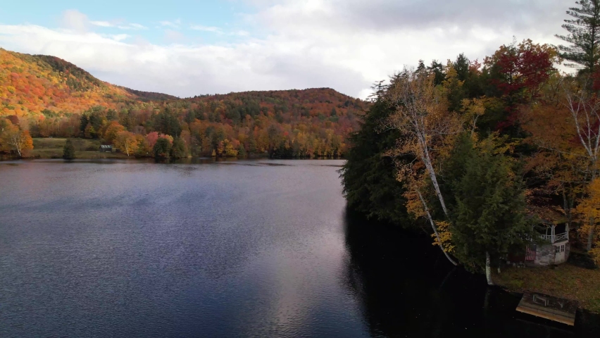 new england lake in fall slow aerial push in