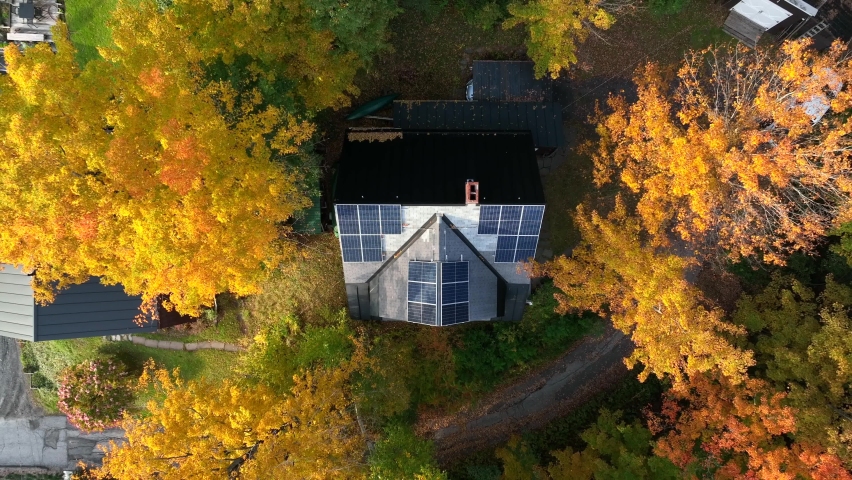 Solar panels on rural mountain home in USA. Rising aerial during shade of autumn fall foliage, yellow tree leaves. Royalty-Free Stock Footage #1096962205