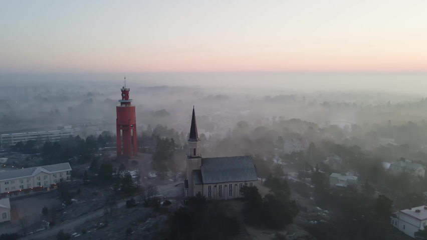 Aerial view around the church and water tower, foggy, spring morning in Hanko, Finland - orbit, drone shot
