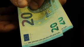 A man counts bills at 20 euros, close-up, slowed down