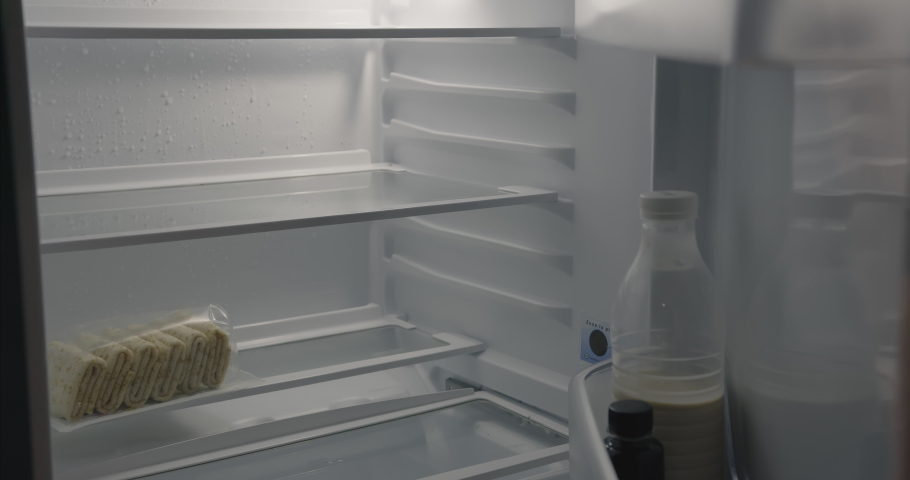 The empty refrigerator opens. Small refrigerator with a semi-finished product.