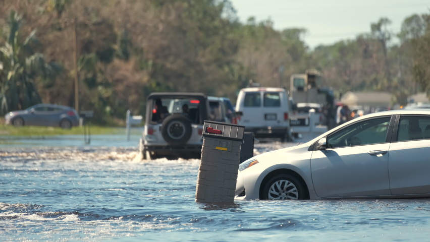 Hurricane Ian flooded street with moving cars in surrounded with water Florida residential area. Consequences of natural disaster Royalty-Free Stock Footage #1096967755