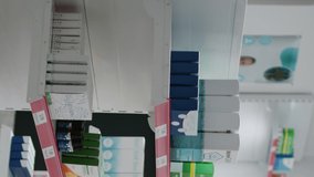 Vertical video: Drugstore desk and shelves having boxes of pills and medication, containers of medicaments and supplements. Empty pharmacy shop with drugs packages and pharmaceutical products.