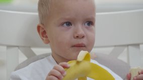 Little toddler child eating banana
