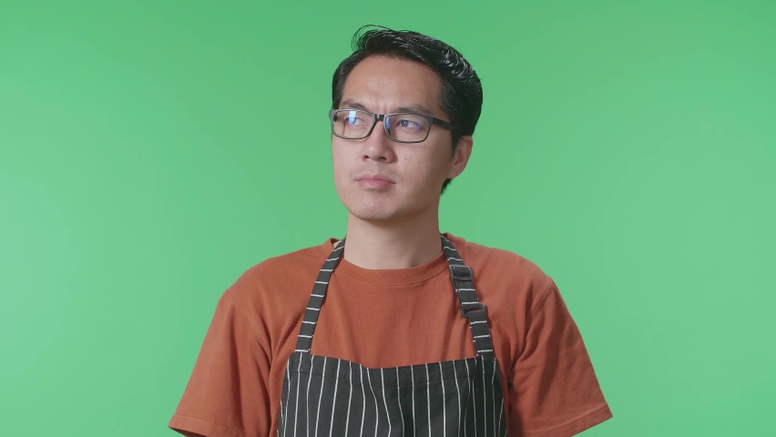 Close Up Of Asian Male Housekeeper With An Apron Thinking About Something And Looking Around While Standing In The Green Screen Studio
 | Shutterstock HD Video #1096979175
