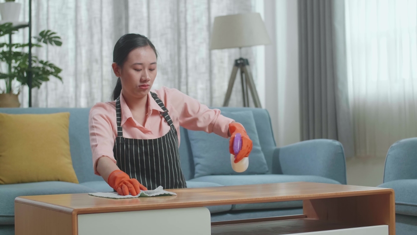 Upset Asian Female Housekeeper With An Apron Crying While Cleaning The Table By The Spray At Home
 | Shutterstock HD Video #1096979233