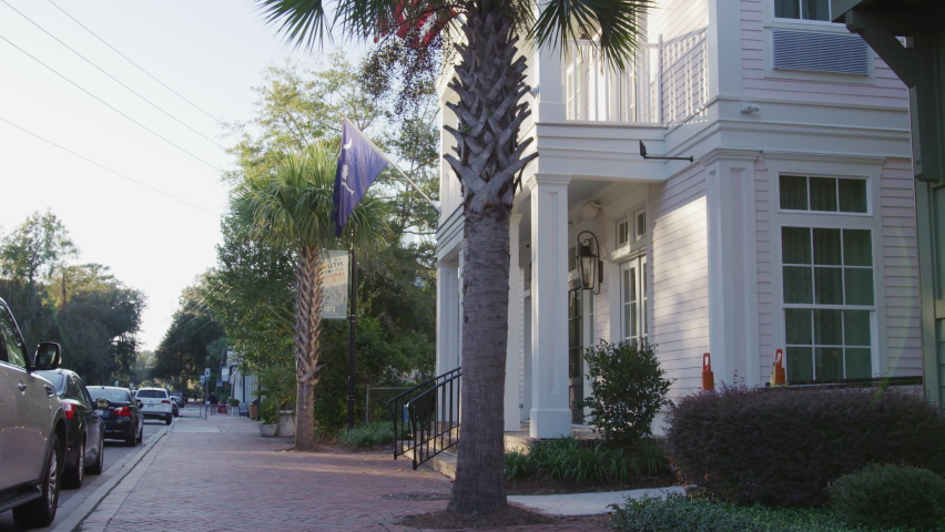 Buildings and American flag on main street of Bluffton, South Carolina in summer on sunny day in slow motion