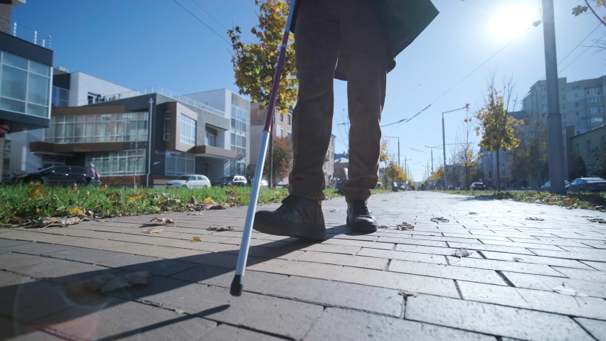 Blind person using white cane on straight tactile tiles to navigate road Royalty-Free Stock Footage #1096984837