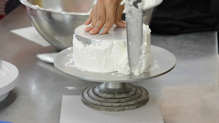 chef spread cream on model cake