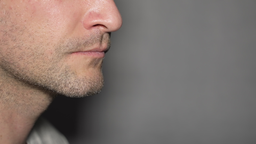 Side view of lower part young male face speaking, copy space. unshaven man saying.  | Shutterstock HD Video #1096997613