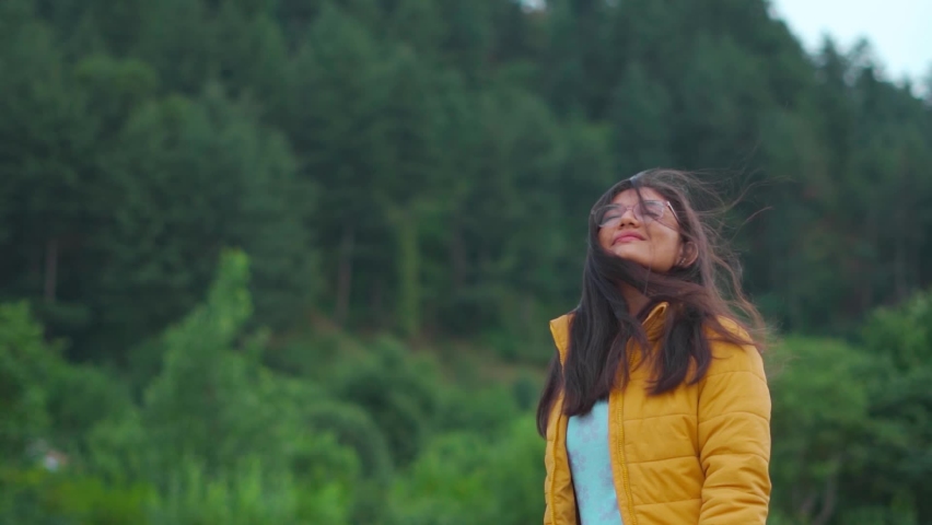 Portrait of beautiful Indian woman standing in background of pine forest at Manali, Himachal Pradesh, India. Female enjoying nature in background of green trees during summer in Manali | Shutterstock HD Video #1096997947