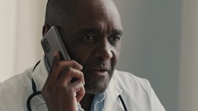 African American ethnic doctor man therapist medical worker consult patient by mobile phone male professional adviser physician speak distant virtual medicine assistance modern healthcare technology - Powered by Shutterstock - Get 15% off with code: PIKWIZARD15
