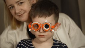 Young boy is visiting an ophtalmology clinic with his mom. Hello in french on sweater - Powered by Shutterstock - Get 15% off with code: PIKWIZARD15