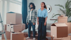 Young tired multiethnic family of African American woman and Arabian man exhausted to sit on sofa after difficult move to new apartment posing in living room own house with boxes. Relocation, moving - Powered by Shutterstock - Get 15% off with code: PIKWIZARD15