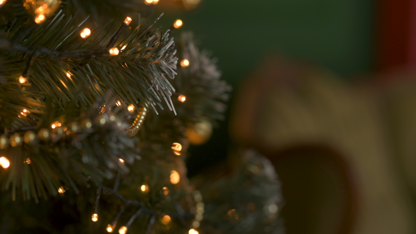 Hands hang a golden New Year's ball on a Christmas tree. Women's hands decorate the Christmas tree. Merry christmas and a happy new year . Royalty-Free Stock Footage #1097013363