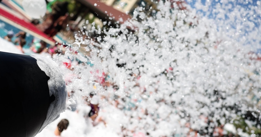Foam party on beach blowing from cannon