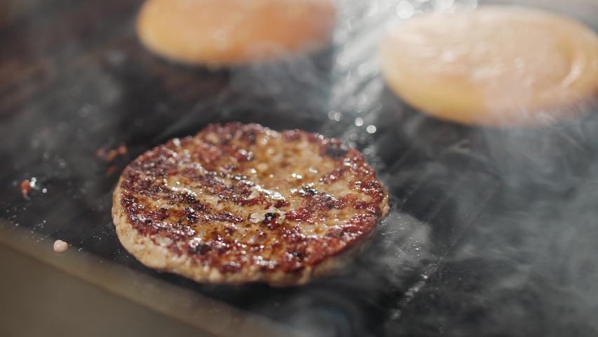 Street food, the process of cooking a burger on the grill, meat and bun are fried on the grill, burger ingredients, 4k super slow motion. Royalty-Free Stock Footage #1097015621