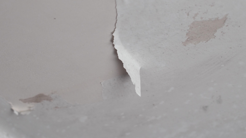 Hand peeling paint on bathroom ceiling rotting due to dampness and water leakage Royalty-Free Stock Footage #1097018029