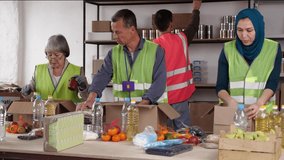 A multiethnic group of volunteers is collecting donations. Senior Asian, Muslim, young Europeans, students. Refugee camp from the war in Ukraine - Powered by Shutterstock - Get 15% off with code: PIKWIZARD15