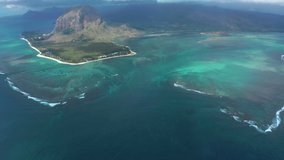 Drone flight over the island of Mauritius in the Indian Ocean. Underwater waterfall in a coral reef from a bird's eye view. Turquoise water is the dream of a tourist and traveler
