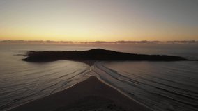 Drone video flying toward Shark Island, Fingal Bay, just before sunrise
