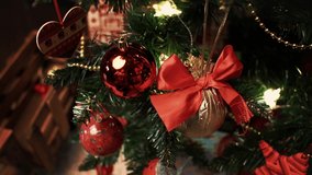Closeup of christmas ornament decorations, balls and garland hang on xmas tree. Wrapped red gift boxes and bright lights in living room, copy space. Winter holidays concept. Texture and background - Powered by Shutterstock - Get 15% off with code: PIKWIZARD15
