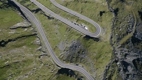 Amazing aerial video with the famous Transfagarasan mountain road between Transylvania and Muntenia with many vehicles slowly coming around the bends, Romania