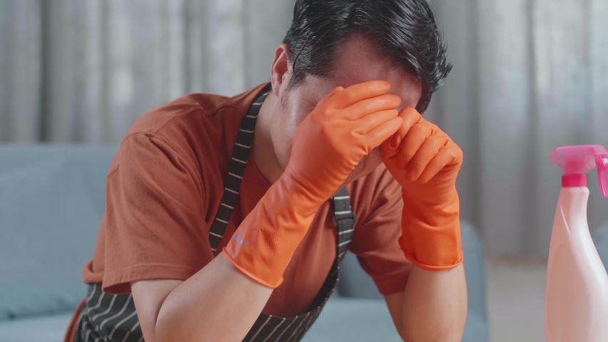 Close Up Of Upset Asian Male Housekeeper With An Apron Crying While Cleaning The Table By The Spray At Home
 | Shutterstock HD Video #1097031071