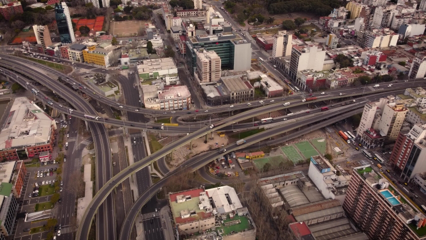 Aerial birds eye shot showing traffic on highway and bridges in Buenos Aires City, Puerto Madero area at sunset