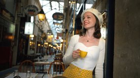 Portrait of a young girl with a yellow cup of coffee in a Parisian gallery