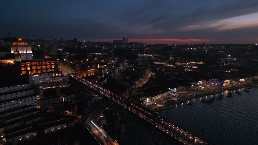 Aerial panoramic view of the Dom Luis I Bridge over the Douro river at dusk in Porto (Oporto), Portugal.  Royalty-Free Stock Footage #1097048927