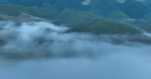 sea of fog move flowing over mountain and sapan village in the valley, tourist attractions and important landmarks of Nan Province Northern Thailand, footage 4k video aerial drone point of view,