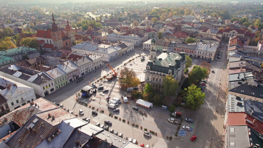 Aerial view of the central market square at sunrise in Nowy Sacz town, Poland. Town Hall and Saint Margaret of Antioch Basilica in Nowy Sacz city. Orbit shot. 