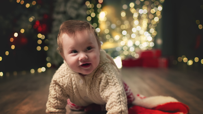baby happily crawls on camera on Eve. Family Spending Winter Evening at Home. Young Mother with Little Kid Son play. Slow Motion. Christmas, New Year, Winter Holiday Celebration. 4K 10 bit colors Royalty-Free Stock Footage #1097064289