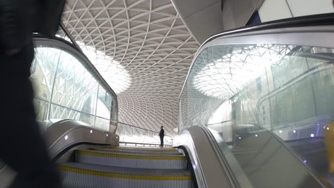 LONDON - JUNE 17, 2015: Businessman on escalators inside King's Cross railway station, a major London railway terminus which opened in 1852 on the northern edge of central London.
