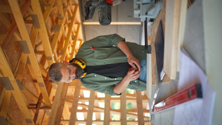 Man working on buidling site of wooden eco house.